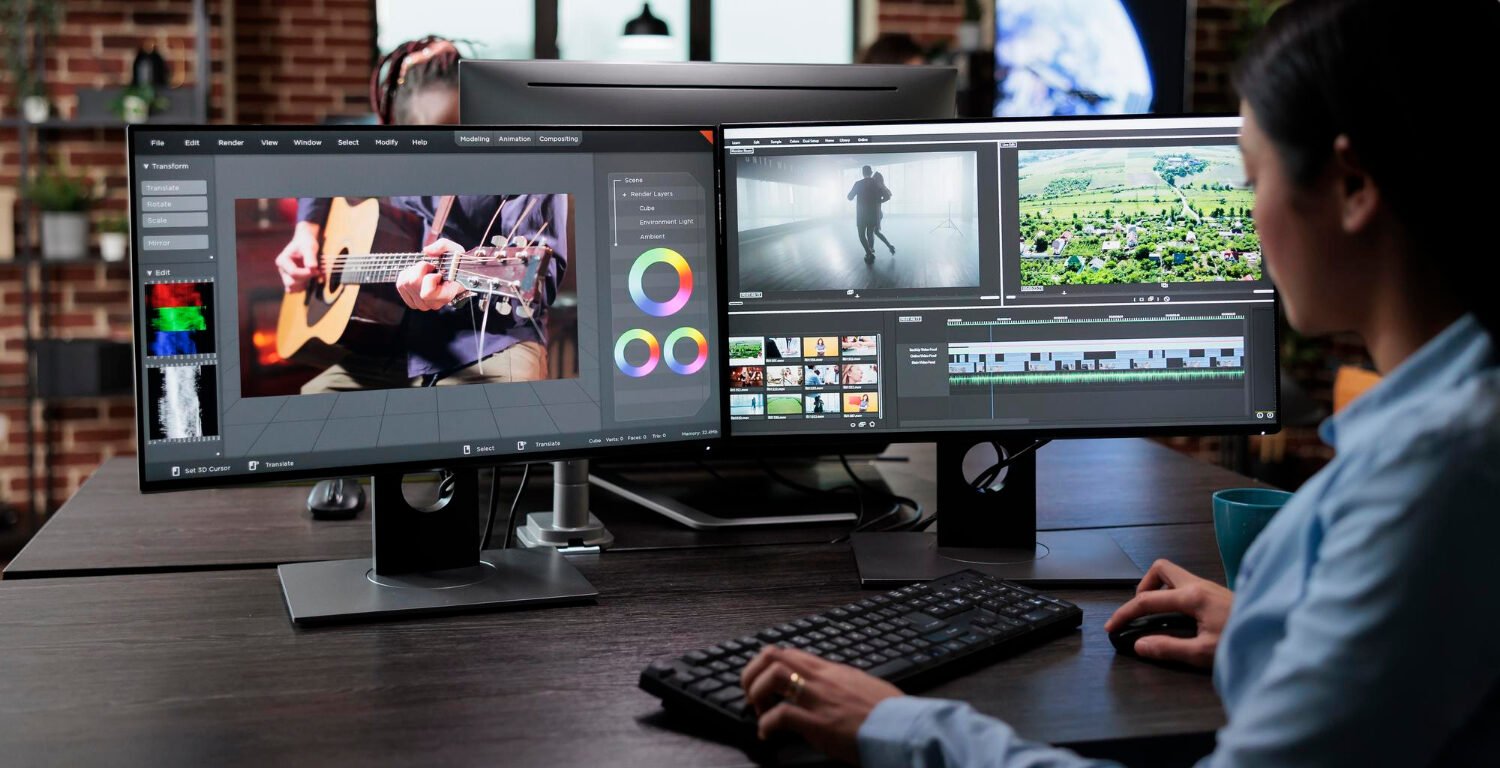 woman working on two large monitors and editing videos