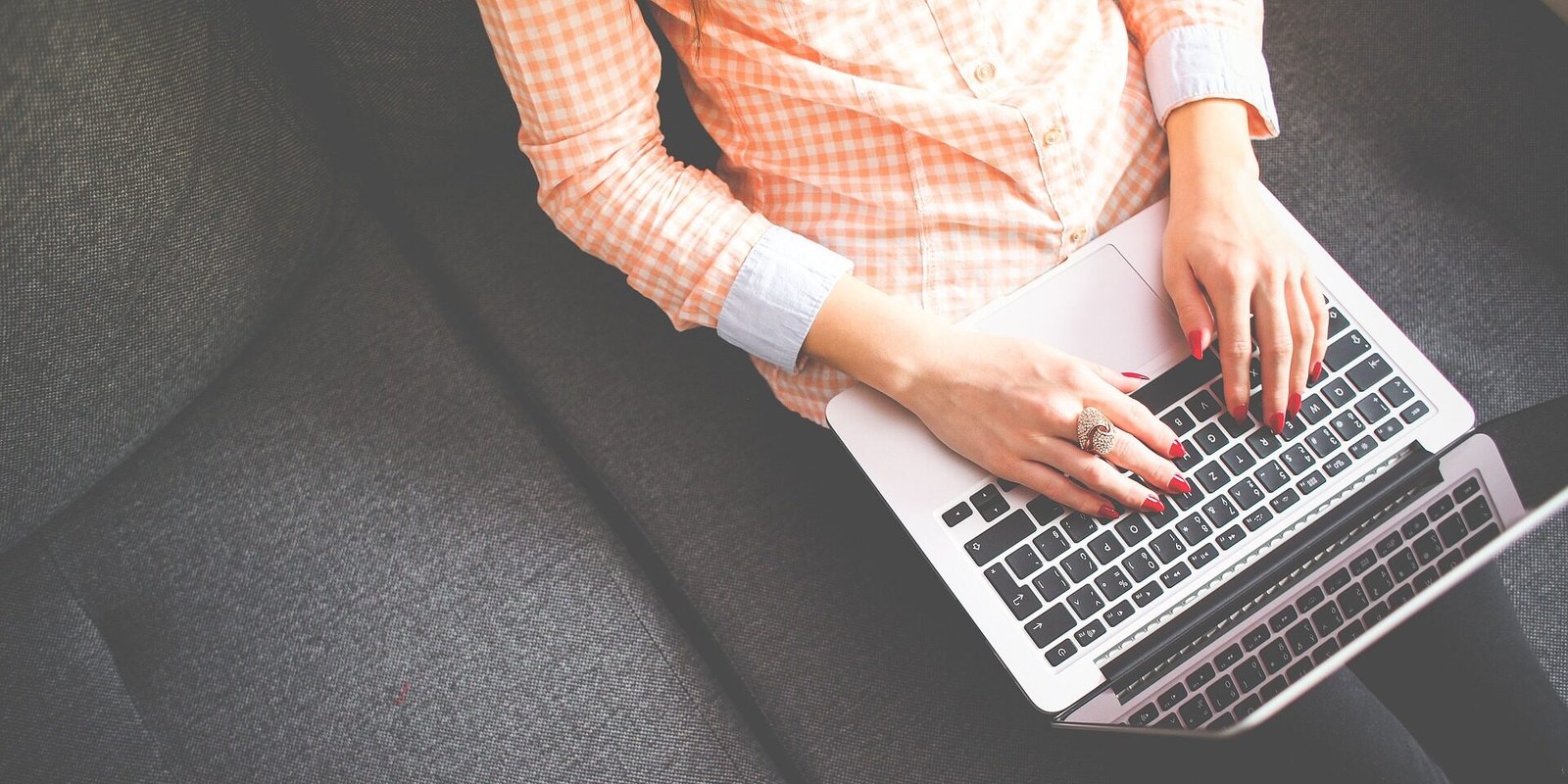 Overhead view of a woman typing on a laptop