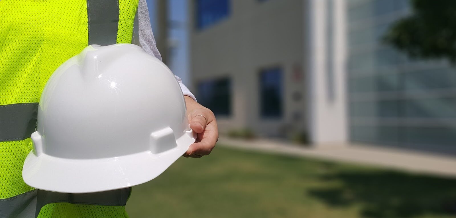 A construction worker holding his helmet.